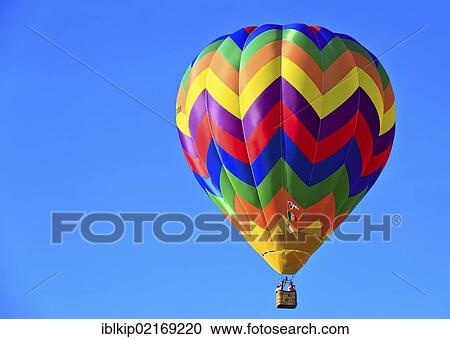 Stock Image - Hot air balloon drifting in the blue sky, Ferrara balloon festival, Italy, Europe. Fotosearch