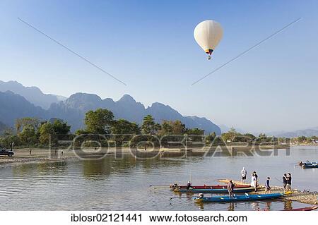 Hot air balloon flying over the karst mountains at the Nam Song River, Vang Vieng, Vientiane, Laos, Indochina, Asia View Large Photo Image Stock Image - Hot air balloon flying over the karst mountains at the Nam Song River, Vang Vieng, Vientiane, Laos, Indochina, Asia. Fotosearch