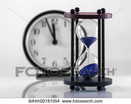 Hourglass and clock, 11: 55, almost high noon View Large Photo Image Picture - Hourglass and clock, 11: 55, almost high noon. Fotosearch