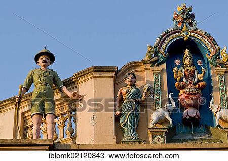 Stock Image - Indian Goddess Lakshmi flanked by elephants and British soldier in Uniform with a rifle, sculptural decoration on an old house, Karaikudi, Chettinad, Tamil Nadu, South India, India, Asia. Fotosearch