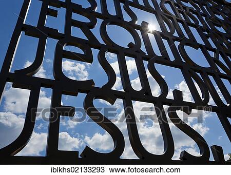 Stock Image - "Jesus" lettering against a blue sky in the Gardens of the World, Berlin, Germany, Europe. Fotosearch