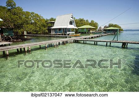 Jetty in the clear water and a typical wooden house on the small Caribbean island of Coral Key, Bocas del Toro, Panama, Central America, North America View Large Photo Image Stock Photo - Jetty in the clear water and a typical wooden house on the small Caribbean island of Coral Key, Bocas del Toro, Panama, Central America, North America. Fotosearch