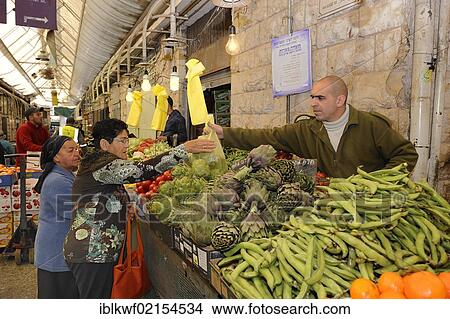 Picture - Jewish vendor offering a variety of fresh vegetables, including beans and artichokes, for sale on a stall at the Jewish Mahane Yehuda market, Jaffa Road, Jerusalem, Israel, Middle East, Southwest Asia, Asia. Fotosearch