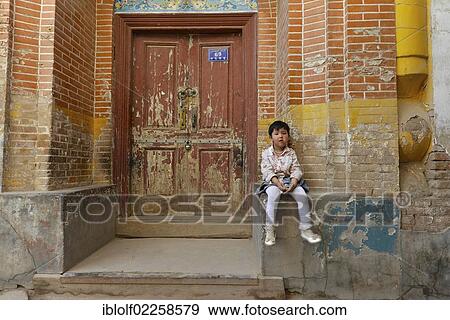 Little girl sitting on the brick wall facade in an alley of the Uighur residential district, Uyghurs, Silk Road, Kashgar, Xinjiang, China, Asia View Large Photo Image Stock Photo - Little girl sitting on the brick wall facade in an alley of the Uighur residential district, Uyghurs, Silk Road, Kashgar, Xinjiang, China, Asia. Fotosearch