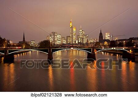 Stock Photo - Main river with the illuminated Frankfurt skyline at dusk, Frankfurt am Main, Hesse, Germany, Europe. Fotosearch