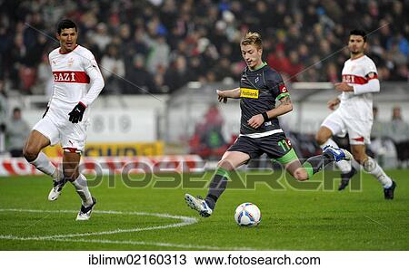 Stock Image - Marco Reus from Borussia Moenchengladbach shooting the goal for the score of 0: 2, in front of Maza, VfB Stuttgart, left, and Serdar Tasci, VfB Stuttgart, right, Mercedes-Benz Arena, Stuttgart, Baden-Wuerttemberg, Germany, Europe. Fotosearch