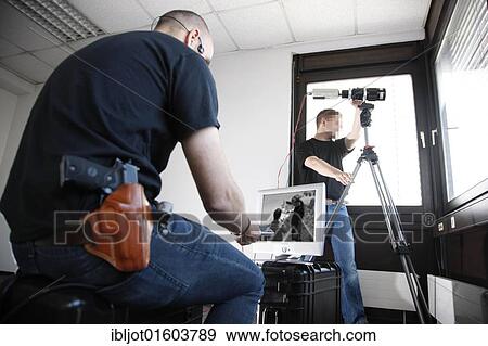 Members of a technical task force of the special police unit using a video camera for surveillance, money transfer between two criminals, operational rehearsal, North Rhine-Westphalia, Germany, Europe View Large Photo Image Stock Photo - Members of a technical task force of the special police unit using a video camera for surveillance, money transfer between two criminals, operational rehearsal, North Rhine-Westphalia, Germany, Europe. Fotosearch