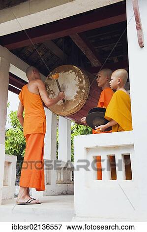 Stock Photo - Monk drumming at the Wat Sop Sickharam Temple, Luang Prabang, UNESCO World Heritage Site, Laos, Indochina, Asia. Fotosearch