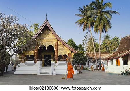 Stock Photograph - Monks sweeping the temple in the morning, Wat Sibounheuang, Luang Prabang, UNESCO World Heritage Site, Laos, Indochina, Asia. Fotosearch