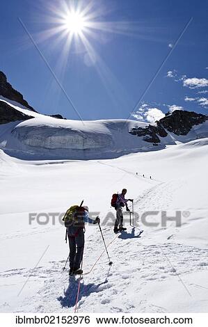 Stock Photograph - Mountain climbers ascending Piz Palue Mountain through the glacial landscape, Grisons, Switzerland, Europe. Fotosearch