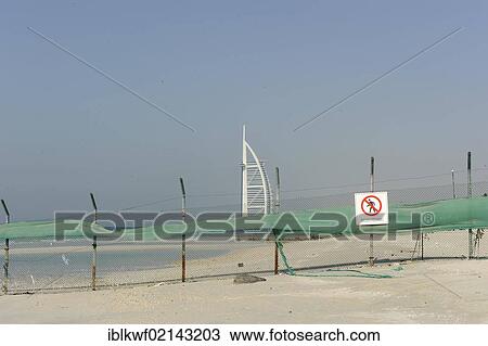 Stock Image - No Trespassing, sign with fencing, Burj al Arab, Tower of the Arabs, hotel, landmark, Jumeirah Group, United Arab Emirates, Arabian Peninsula, Asia. Fotosearch