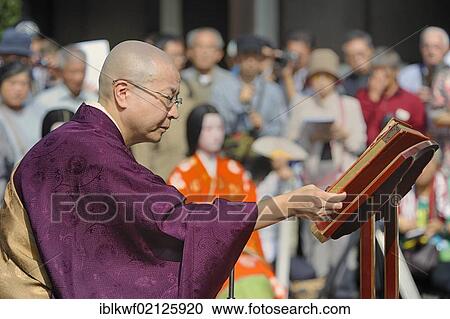 Stock Image - Nun wearing sutras for a Buddhist memorial service, so that the souls of the dolls can be redeemed, Hokyo-ji Temple, Kyoto, Japan, East Asia, Asia. Fotosearch
