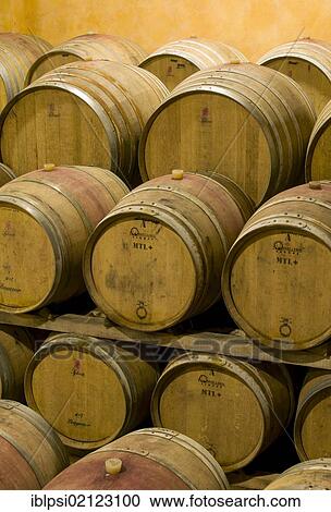 Stock Image - Oak wine barrels in wine cellar in Montalcino, Toscana, Tuscany, Italy, Europe. Fotosearch