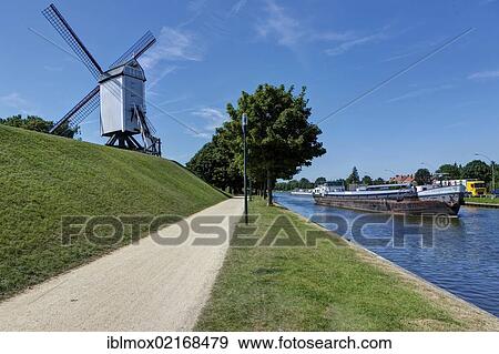 Old windmill at the Vlaanderen Fietsroute, Flanders Bike Trail, at the Coupure Canal, Bruges, West Flanders, Flemish Region, Belgium, Europe View Large Photo Image Stock Photo - Old windmill at the Vlaanderen Fietsroute, Flanders Bike Trail, at the Coupure Canal, Bruges, West Flanders, Flemish Region, Belgium, Europe. Fotosearch