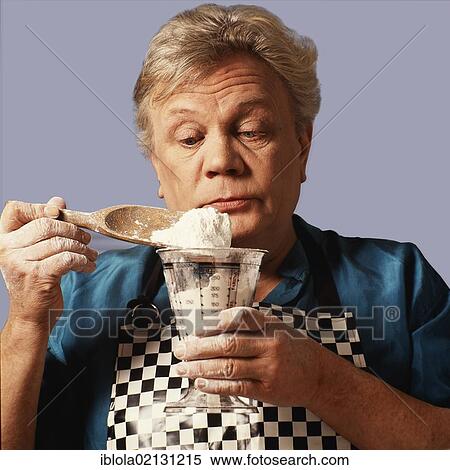 Stock Photography - Older diabetic man weighing flour, minding the right amount of ingredients whilst cooking to maintain a healthy diet. Fotosearch