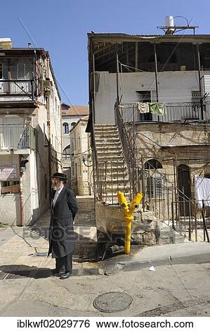 Stock Photograph - Orthodox Jew with typical houses in the district of Me'a She'arim or Mea Shearim, Jerusalem, Israel, Middle East, Asia. Fotosearch
