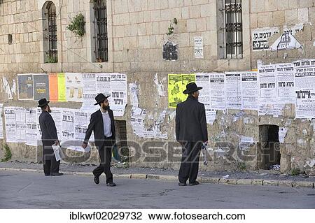 Stock Image - Orthodox Jews reading wall newspapers in the district of Me'a She'arim or Mea Shearim, Jerusalem, Israel, Middle East, Asia. Fotosearch