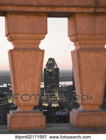 Stock Photo - Partial view of the Montreal skyline through a stone railing at the lookout on Mt Royal at dawn, Quebec, Canada, North America. Fotosearch