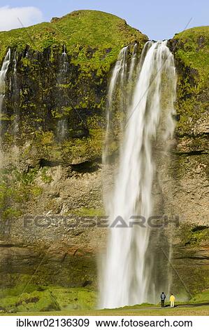 Stock Photo - People in front of Seljalandsfoss Waterfall, Iceland, Europe. Fotosearch