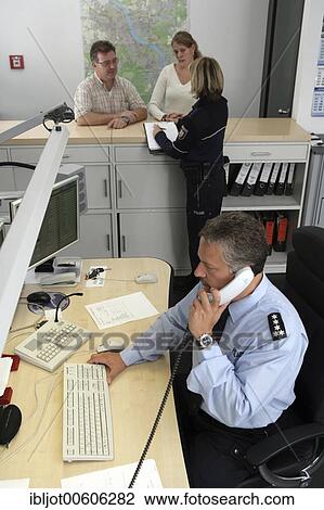Stock Image - Police officer making a phone call at the office, new blue police uniforms worn by 1400 male and female North Rhine-Westphalian police officers, Duesseldorf, North Rhine-Westphalia, Germany, Europe. Fotosearch