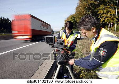 Police officers of the highway patrol errecting a radar measuring decice on the A2 highway for speed monitoring, Germany, Europe View Large Photo Image Stock Image - Police officers of the highway patrol errecting a radar measuring decice on the A2 highway for speed monitoring, Germany, Europe. Fotosearch