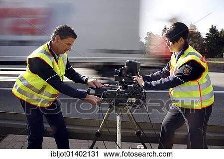 Stock Image - Police officers of the highway patrol errecting a radar measuring decice on the A2 highway for speed monitoring, Germany, Europe. Fotosearch