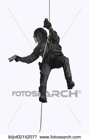 Stock Photo - Police, Special Task Force, SEK, police officer wearing full protective gear holding a pistol while abseiling on a rope. Fotosearch