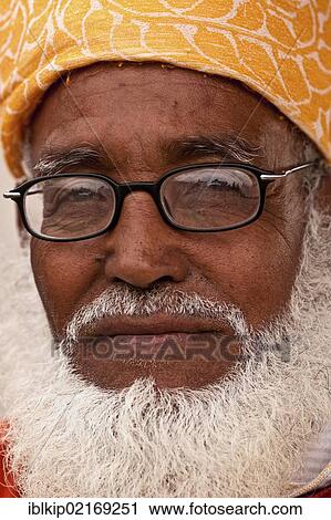 Stock Image - Portrait of an elderly of man with glasses and white beard, wearing traditional turban, Marrakesh, Morocco, Africa. Fotosearch