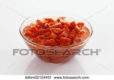 Stock Image - Preserved food, diced carrots in a glass bowl. Fotosearch