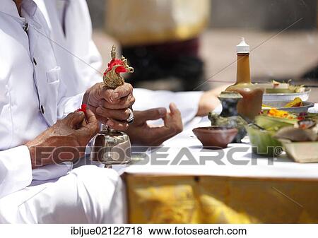 Stock Photo - Priest holding a small bell during a Hindu temple ceremony, Nusa Dua, Bali, Indonesia, Southeast Asia, Asia. Fotosearch