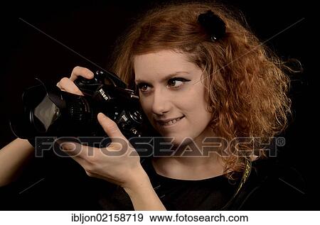 Red-haired woman taking pictures with a camera View Large Photo Image Stock Photo - Red-haired woman taking pictures with a camera. Fotosearch