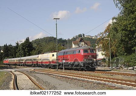 Stock Image - Rheingold train with a TEE locomotive 103 235 being pulled by a Class 218 diesel engine, in front of Schloss Wittgenstein Castle, Bad Laasphe, Siegen Wittgenstein district, North Rhine-Westphalia, Germany, Europe. Fotosearch
