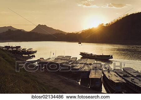 River boats on the Mekong River at sunset, Luang Prabang, Laos, Indochina, Asia View Large Photo Image Stock Photograph - River boats on the Mekong River at sunset, Luang Prabang, Laos, Indochina, Asia. Fotosearch