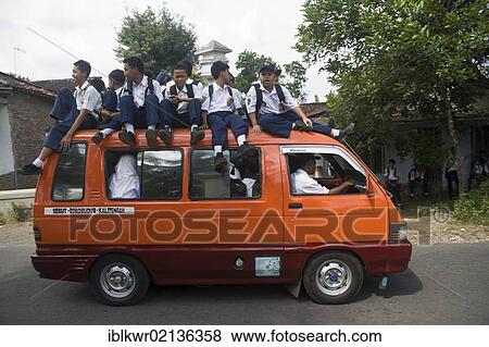 Stock Photo - School children being driven to school in and on a school bus, Java, Indonesia, Asia. Fotosearch