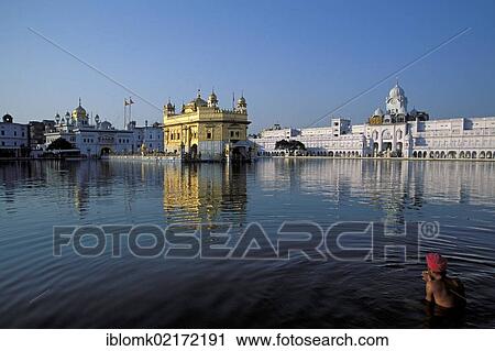 Stock Image - Sikh man taking a holy bath in Amrit Sagar, "Lake of Nectar", Golden Temple, Amritsar, Punjab, North India, India, Asia. Fotosearch