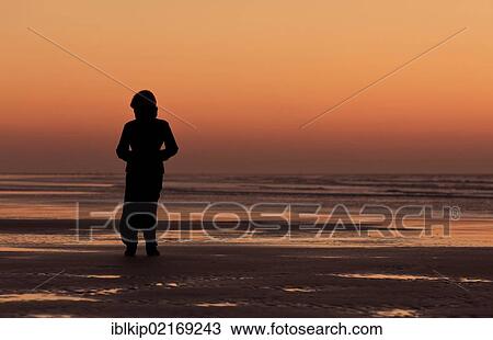 Silhouette of a woman on the beach looking into the sunset, Essaouira, Morocco, Africa View Large Photo Image Stock Image - Silhouette of a woman on the beach looking into the sunset, Essaouira, Morocco, Africa. Fotosearch