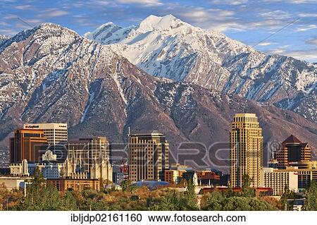 Stock Image - Skyline of downtown Salt Lake City with the towering Wasatch Mountain range at back, Utah, USA, North America. Fotosearch