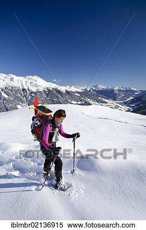 Stock Photography - Snowshoe hiker ascending to Jagelealm alpine pasture in Ridnauntal Valley above Entholz, looking towards the Ridnauntal Valley and Rosskopf Mountain, Alto Adige, Italy, Europe. Fotosearch
