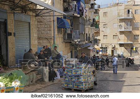 Stock Image - Street scene, a group of men sitting in front of the Mahane Yehuda Market, Jerusalem, Israel, Middle East, Asia. Fotosearch