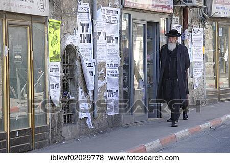 Stock Photo - Street scene with an Orthodox Jew and typical wall newspapers in the district of Me'a She'arim or Mea Shearim, Jerusalem, Israel, Middle East, Asia. Fotosearch
