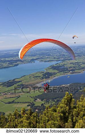 Tandem paragliders overlooking Froggensee lake, Tegelberg Mountain, Upper Bavaria, Bavaria, Germany, Europe, PublicGround, Europe View Large Photo Image Stock Photo - Tandem paragliders overlooking Froggensee lake, Tegelberg Mountain, Upper Bavaria, Bavaria, Germany, Europe, PublicGround, Europe. Fotosearch