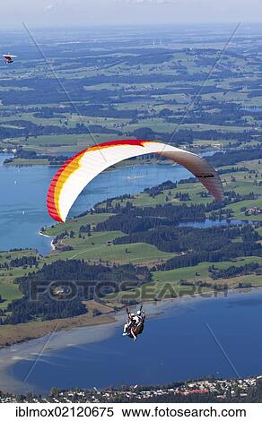 Tandem paragliders overlooking Froggensee lake, Tegelberg Mountain, Upper Bavaria, Bavaria, Germany, Europe, PublicGround, Europe View Large Photo Image Stock Photography - Tandem paragliders overlooking Froggensee lake, Tegelberg Mountain, Upper Bavaria, Bavaria, Germany, Europe, PublicGround, Europe. Fotosearch