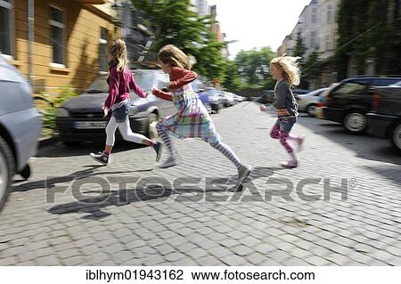 Three girls running in a residential street in the centre of Dusseldorf, North Rhine-Westphalia, Germany, Europe View Large Photo Image Stock Image - Three girls running in a residential street in the centre of Dusseldorf, North Rhine-Westphalia, Germany, Europe. Fotosearch