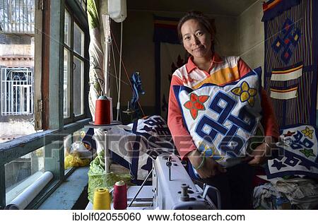 Stock Image - Tibetan handicrafts, dressmaker with Buddhist symbols on textiles, textile art, Tibet, Lhasa, China, Asia. Fotosearch