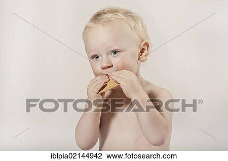 Stock Image - Toddler, boy, 1, eating a cookie. Fotosearch