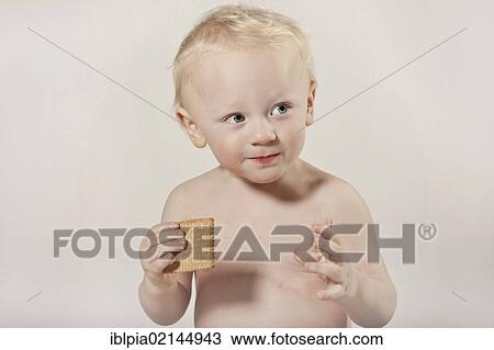 Stock Image - Toddler, boy, 1, eating a cookie. Fotosearch