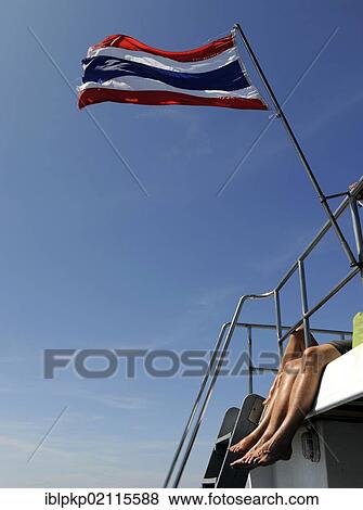 Tourists sunbathing their legs on a ship flying the Thai flag, Thailand, Asia View Large Photo Image Stock Photo - Tourists sunbathing their legs on a ship flying the Thai flag, Thailand, Asia. Fotosearch