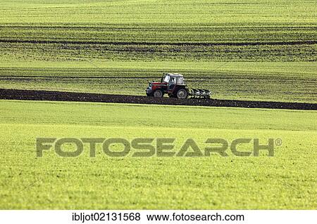 Stock Photo - Tractor harrowing a field, preparing the soil for the sowing of new crops, Eschweiler, North Rhine-Westphalia, Germany, Europe. Fotosearch