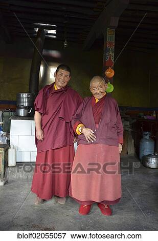 Two Buddhist nuns, one middle-aged woman, one elderly woman, over 70 years, wearing red robes at the monastery entrance, Gongkar Chode monastery, Lhasa, Tibet, China, Asia View Large Photo Image Stock Photo - Two Buddhist nuns, one middle-aged woman, one elderly woman, over 70 years, wearing red robes at the monastery entrance, Gongkar Chode monastery, Lhasa, Tibet, China, Asia. Fotosearch