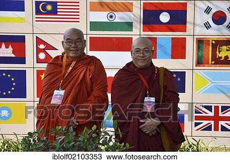 Two monks with red and orange robes, participants of the Global Buddhist Congregation 2011, Buddhist dignitaries from various Buddhist traditions and schools are photographed in front of national flags in Nehru Park, Gandhi Smitri, New Delhi, India, Asia View Large Photo Image Stock Image - Two monks with red and orange robes, participants of the Global Buddhist Congregation 2011, Buddhist dignitaries from various Buddhist traditions and schools are photographed in front of national flags in Nehru Park, Gandhi Smitri, New Delhi, India, Asia. Fotosearch